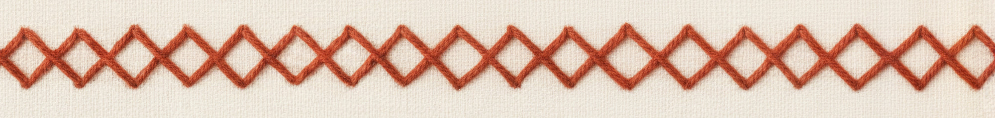 Decorative embroidered red border with wavy lines on a beige background