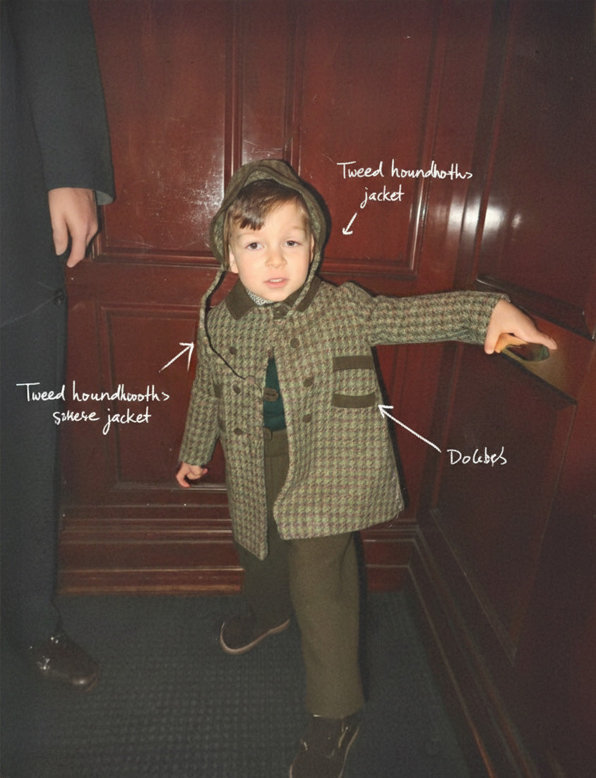 Child wearing a tweed houndstooth jacket in front of a wooden door