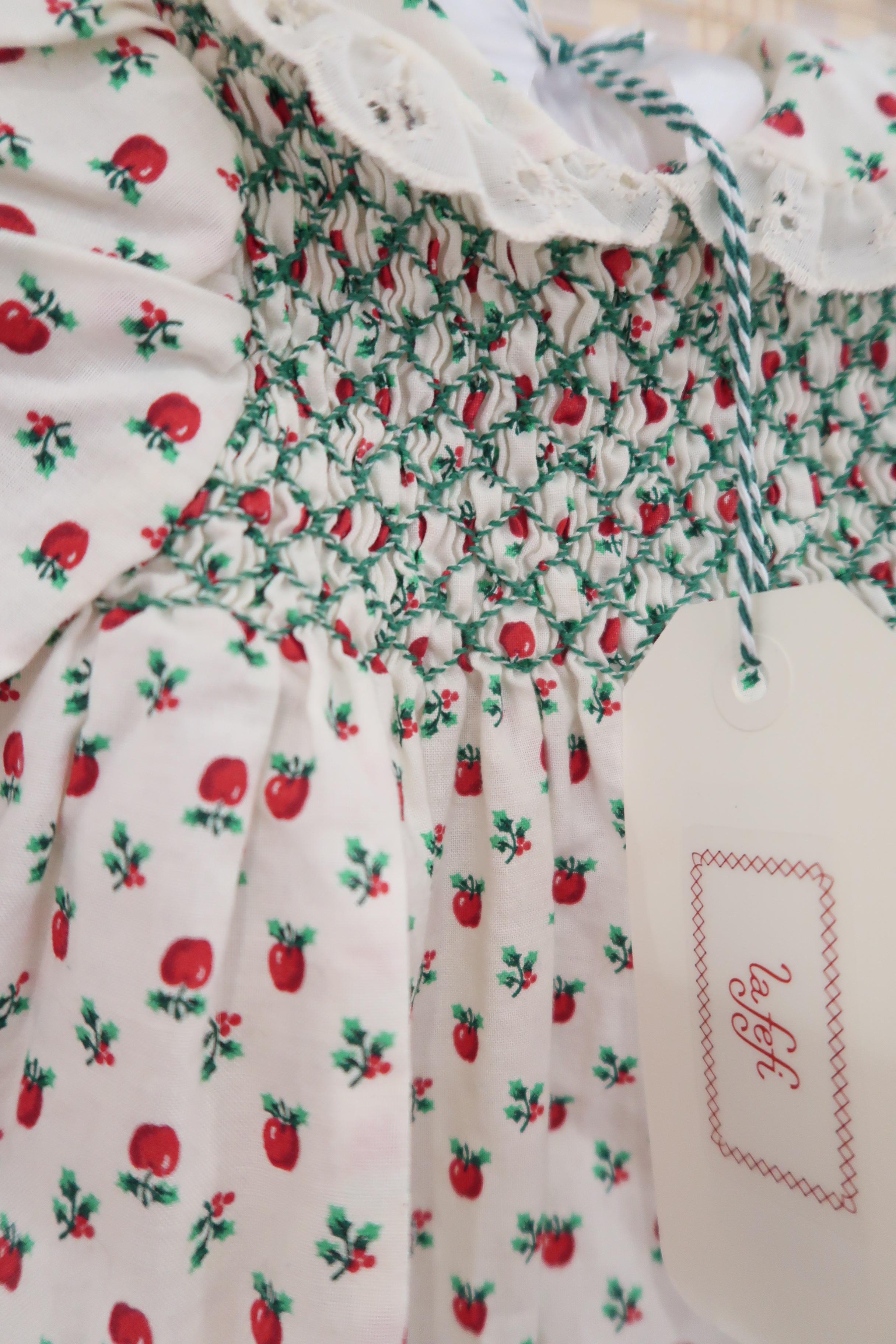Children's dress with red apple pattern and 'La Fefi' brand tag.